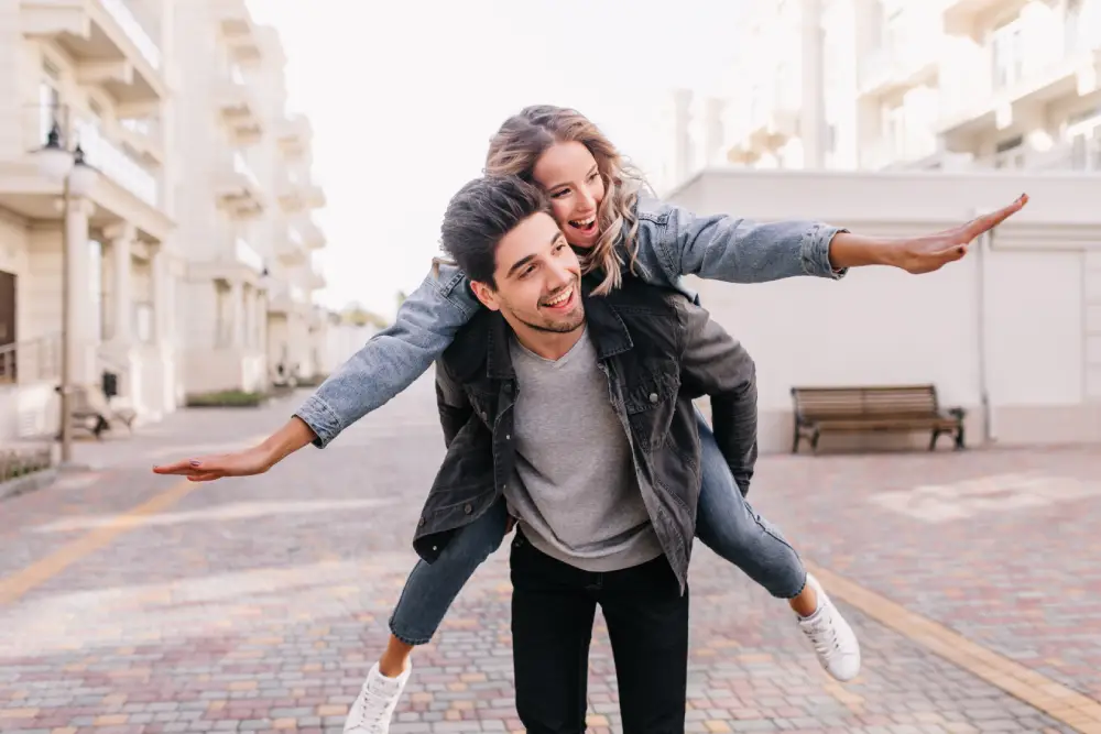 Couple sharing joyful piggyback ride during romantic photo session Couple sharing joyful piggyback ride during romantic photo session